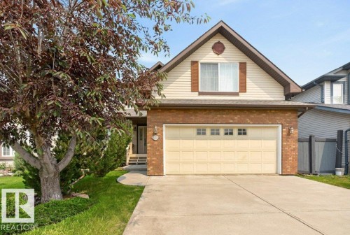 Single-family dwelling featuring brick and siding facade, an attached two-car garage with paneling, a concrete driveway, and a front entrance with steps - 572 Byrne Crescent, Edmonton, AB 