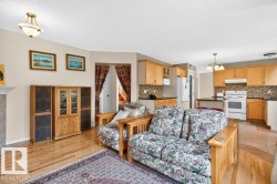 Open-concept living space featuring wood-finish flooring extending into the kitchen area - 