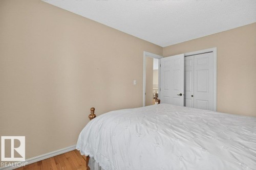 Bedroom featuring light neutral wall paint and wood-finish flooring - 572 Byrne Crescent, Edmonton, AB 