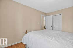 Bedroom featuring light neutral wall paint and wood-finish flooring - 