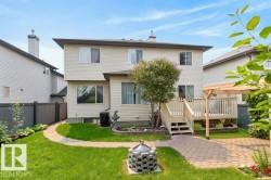 Rear exterior featuring light-colored siding and a brown roof - 