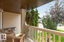 Covered front porch featuring wood-finish decking and neutral siding - 