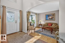Entryway featuring a double door with decorative glass inserts, a transom window, and a tile-and-wood-finish flooring combination - 