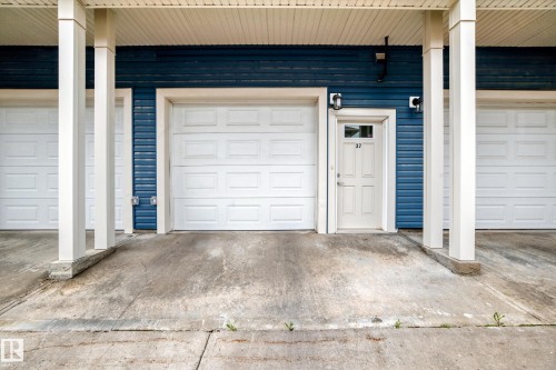 Exterior entrance featuring blue horizontal siding and white trim - 37 13003 132 Avenue Nw, Edmonton, AB 
