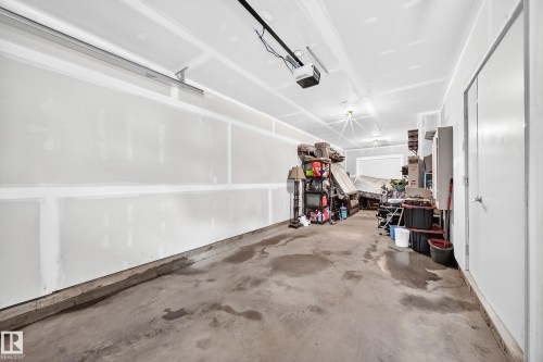 Garage with concrete flooring, unpainted drywall, and a ceiling-mounted garage door opener - 37 13003 132 Avenue Nw, Edmonton, AB 