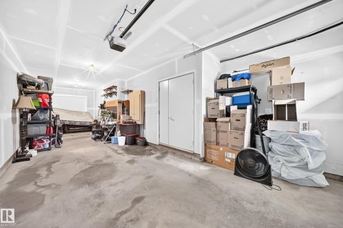Two-car garage featuring a concrete floor, painted drywall, and an overhead garage door opener - 37 13003 132 Avenue Nw, Edmonton, AB 