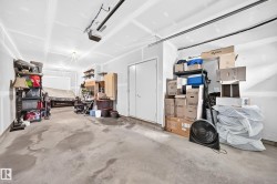 Two-car garage featuring a concrete floor, painted drywall, and an overhead garage door opener - 