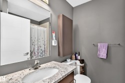 Bathroom featuring a rectangular mirror, a vanity with a white granite-finish countertop and undermount sink, a chrome faucet, and a wall-mounted medicine cabinet - 