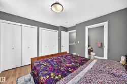 Bedroom featuring wood-finish flooring, two sets of bi-fold closet doors, and recessed shelving - 