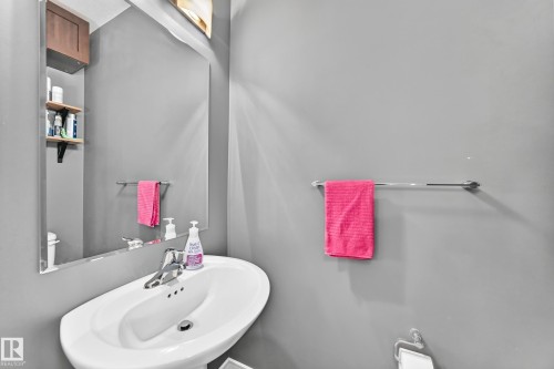 Pedestal sink with chrome faucet set, complemented by a wall-mounted mirror - 37 13003 132 Avenue Nw, Edmonton, AB 