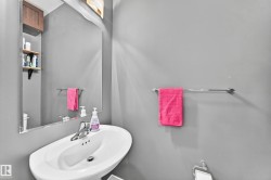 Pedestal sink with chrome faucet set, complemented by a wall-mounted mirror - 