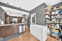 Kitchen island with a granite-style countertop, undermount sink, and stainless steel dishwasher - 
