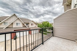 Outdoor balcony featuring a black metal railing and textured flooring - 