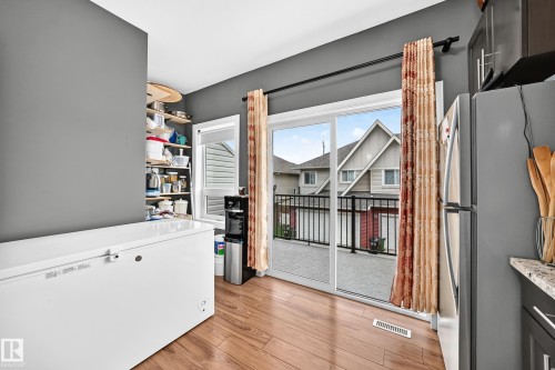 Sliding glass door opening to an exterior balcony with black metal railings - 37 13003 132 Avenue Nw, Edmonton, AB 
