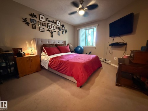 Bedroom featuring neutral carpeting and a window with horizontal blinds - 205 3425 19 Street, Edmonton, AB 