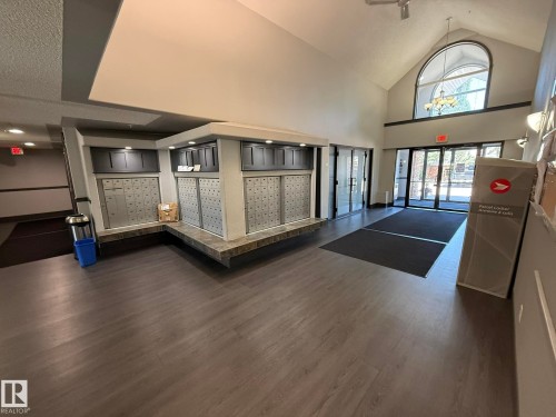Spacious entryway featuring wood-finish flooring and a vaulted ceiling with an arched window - 205 3425 19 Street, Edmonton, AB 