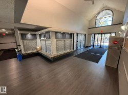 Spacious entryway featuring wood-finish flooring and a vaulted ceiling with an arched window - 