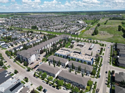 Aerial perspective showcasing a residential area featuring single-family homes, townhouses, and apartment buildings - #205 3425 19 St Nw, Edmonton, AB - Outdoor With View
