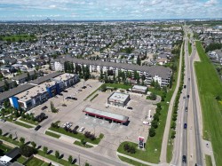Aerial perspective showcasing commercial properties with extensive parking facilities - 