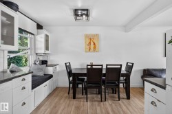 Dining area featuring wood-finish flooring, a contemporary ceiling light fixture, and a built-in window seat with integrated storage - 