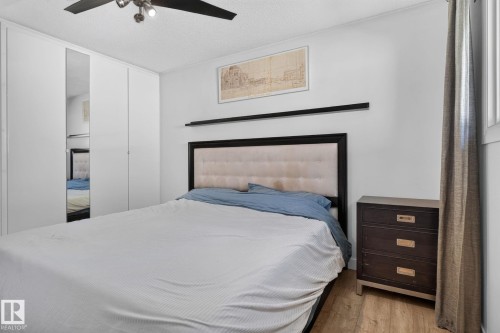 Bedroom featuring wood-finish flooring and a ceiling fan with integrated lighting - 7803 73 Street, Edmonton, AB 
