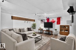 Spacious living area featuring track lighting, wood-finish flooring, and a drop ceiling - 