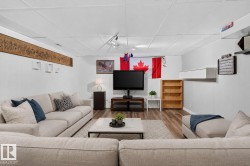 Finished lower level featuring wood-finish flooring, white paneled walls, and a drop ceiling - 