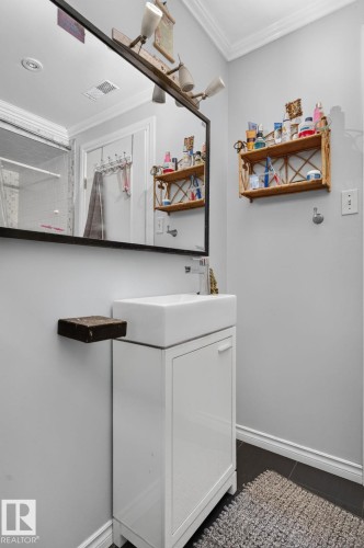 Modern vanity with an integrated rectangular basin, accompanied by a spacious wall-mounted mirror - 7803 73 Street, Edmonton, AB 