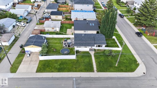 Corner lot property featuring a single-story residence with dark shingle roofing, a well-maintained front lawn, and a concrete pathway - 7803 73 Street, Edmonton, AB 