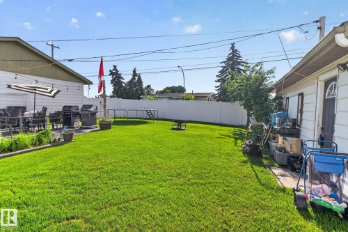 Expansive green lawn backyard featuring a white privacy fence and a rear patio area - 7803 73 Street, Edmonton, AB 