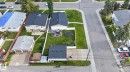 Property featuring a large backyard with a patio, green lawn, and a white privacy fence - 7803 73 Street, Edmonton, AB 