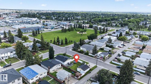 Aerial perspective showcasing a residential street with detached homes, mature trees, and a green space - 7803 73 Street, Edmonton, AB 