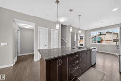 Modern kitchen island featuring a dark wood finish with ample storage and a double basin sink - 