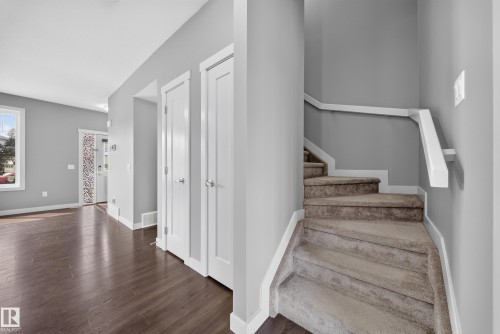 Interior entry space featuring wood-finish flooring, light grey walls, and white trim - 2331 Casey Crescent Sw, Edmonton, AB 