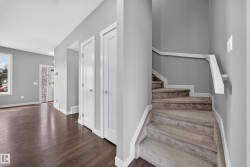 Interior entry space featuring wood-finish flooring, light grey walls, and white trim - 