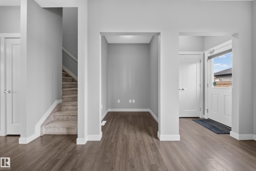 Foyer featuring wood-finish flooring, white trim, and a bright white door with an upper window - 2331 Casey Crescent Sw, Edmonton, AB 