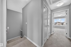 Carpeted hallway with two panel doors and a flush-mount ceiling light - 