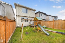 Expansive fenced backyard featuring a grassy lawn, wooden privacy fencing, and a rear deck with white railing - 