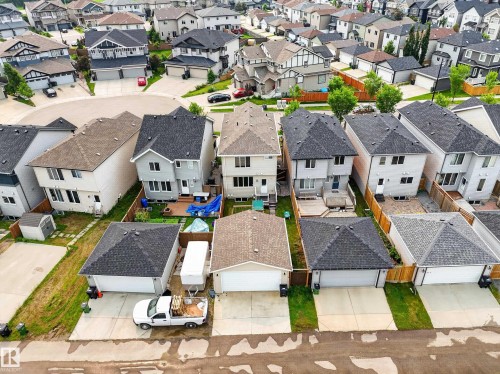 Residential street with detached homes and garages, featuring asphalt shingle roofs and concrete driveways - 2331 Casey Crescent Sw, Edmonton, AB 