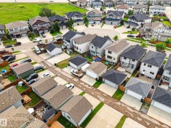 Residential neighborhood featuring multiple detached homes with varying architectural styles, asphalt shingle roofs, and concrete driveways - 
