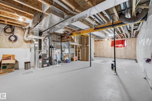 Unfinished basement with painted concrete flooring, visible HVAC ductwork, and exposed ceiling joists - 2331 Casey Crescent Sw, Edmonton, AB 