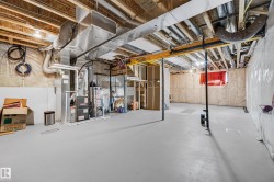 Unfinished basement with painted concrete flooring, visible HVAC ductwork, and exposed ceiling joists - 