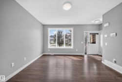 Open concept living area with wood-finish flooring, neutral gray walls, and white baseboards - 