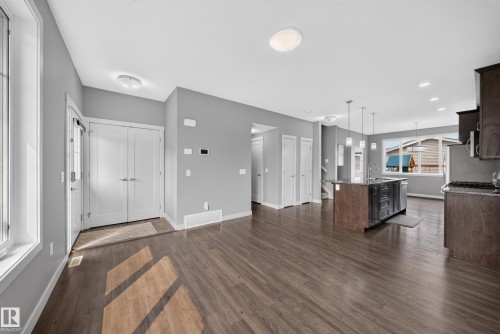Expansive open-concept living area featuring wood-finish flooring, light gray walls, and white trim throughout - 2331 Casey Crescent Sw, Edmonton, AB 