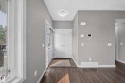 Entryway featuring wood-finish flooring, light grey painted walls, and white trim - 