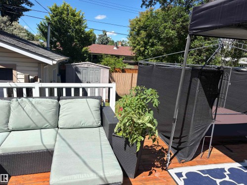 Expansive wood deck with a white railing and privacy screening - 15922 92 Avenue, Edmonton, AB 