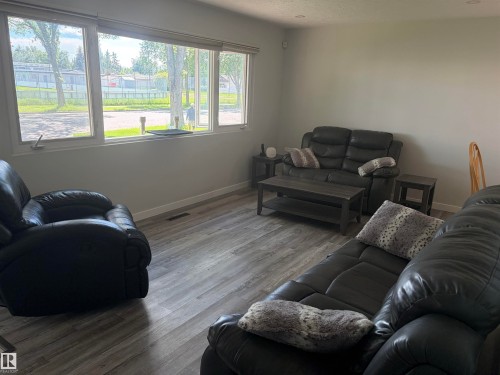 Living area featuring a large window with white trim, wood-finish flooring, recessed lighting, and light-toned walls - 15922 92 Avenue, Edmonton, AB 