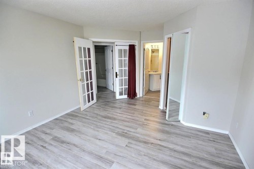 Light gray wood-finish flooring complements neutral wall tones - 9457 156 Street, Edmonton, AB 