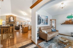 The property features an open-concept layout with vaulted ceilings, hardwood flooring, and a stone fireplace - 