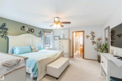 A spacious room featuring carpeting, a ceiling fan, and a view of the outdoors from the window - 